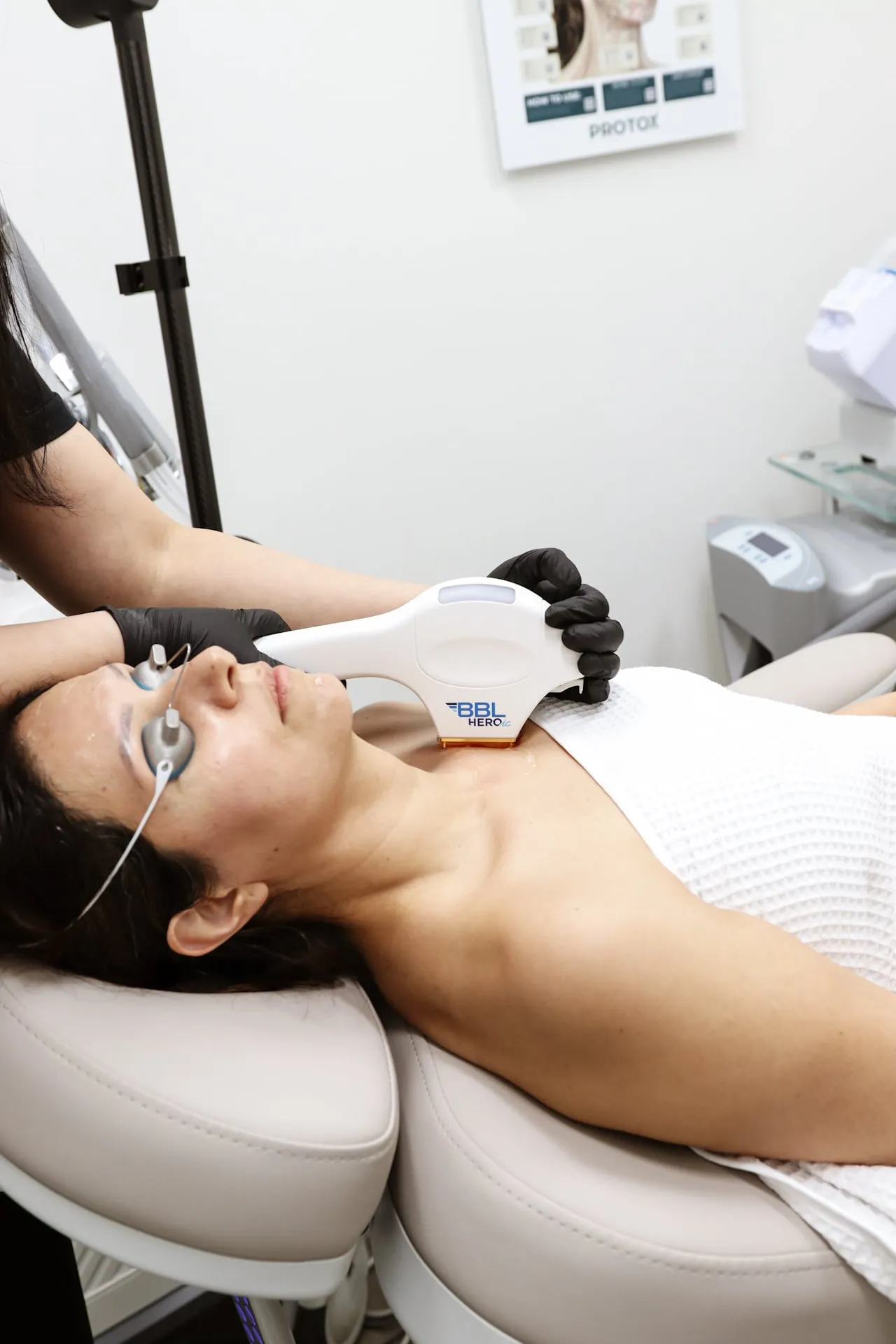 A clinician glides the BBL HERO handpiece across a patient’s face